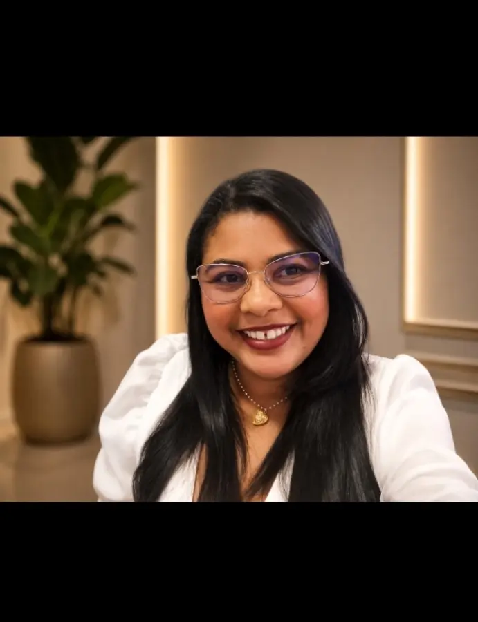 Dalilia Magalhães sorrindo em ambiente acolhedor